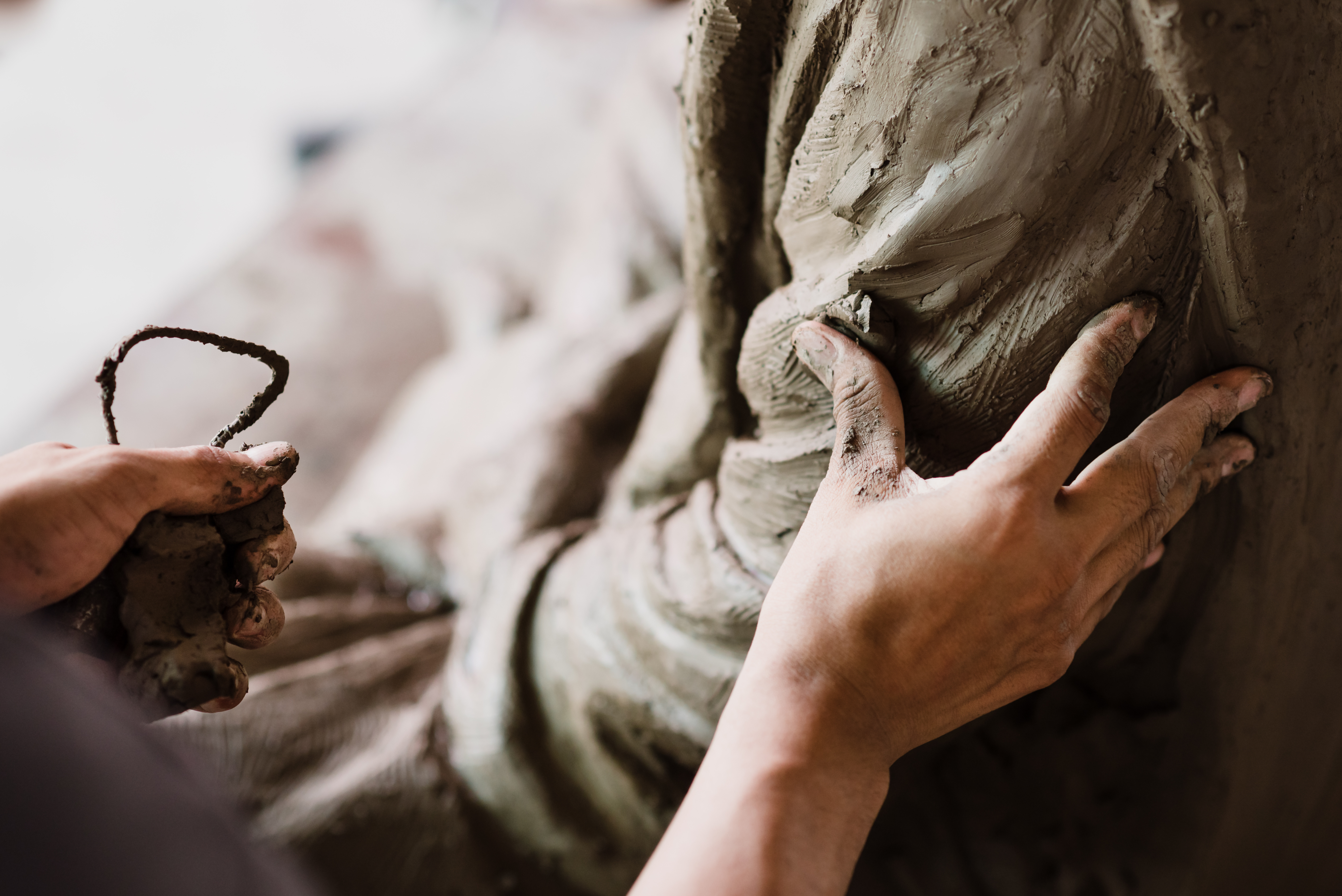 Hands shaping clay on a pottery wheel - representing the ongoing process of identity formation